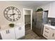 Modern kitchen featuring stainless steel refrigerator, white cabinetry, and an adjacent pantry at 1263 N Willow St, Denver, CO 80220