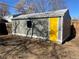 Outdoor shed with a bright yellow door and neutral siding in backyard at 1263 N Willow St, Denver, CO 80220