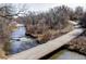 Scenic bike path over a tranquil river, surrounded by lush trees, perfect for leisurely rides and outdoor adventures at 1293 S Monaco Pkwy, Denver, CO 80224