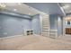 Finished basement with neutral carpet, custom built-in shelving and view into bathroom at 3389 Willowrun Dr, Castle Rock, CO 80109