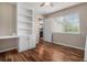 Bedroom featuring a built-in desk and shelving unit, hardwood floors, and a large window at 3389 Willowrun Dr, Castle Rock, CO 80109