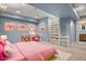 Bright, virtually staged bedroom showcasing pink decor, built-in shelves, and a dedicated study area at 3389 Willowrun Dr, Castle Rock, CO 80109