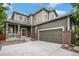 Well-maintained exterior featuring a covered porch, brick accents, and a two-car garage at 3389 Willowrun Dr, Castle Rock, CO 80109
