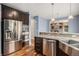 Modern kitchen featuring stainless steel appliances, granite countertops, and dark cabinets at 3389 Willowrun Dr, Castle Rock, CO 80109