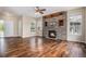 Open living room showcasing hardwood floors, a stone fireplace, and large windows at 3389 Willowrun Dr, Castle Rock, CO 80109