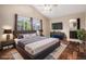 Staged primary bedroom with hardwood floors, ensuite bathroom, and vaulted ceiling at 3389 Willowrun Dr, Castle Rock, CO 80109