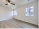 Spacious bedroom with sleek wood-look floors, a ceiling fan, and large windows for lots of natural light at 6491 Barnacle Ct, Boulder, CO 80301