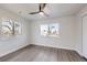 A spacious bedroom with laminate floors, two windows, and a ceiling fan at 6491 Barnacle Ct, Boulder, CO 80301