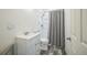 Bathroom featuring a single vanity, toilet, and shower with grey shower curtains at 17788 Olive St, Broomfield, CO 80023
