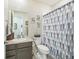 Bathroom featuring a single vanity, toilet, and a shower with blue, grey, and white curtains at 17788 Olive St, Broomfield, CO 80023