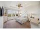 Bright bedroom featuring a trey ceiling, a large window with views, neutral walls, and carpet floors at 17788 Olive St, Broomfield, CO 80023