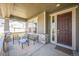 Inviting front porch with chairs, a table, and stylish stone accents, offering a cozy outdoor seating area at 17788 Olive St, Broomfield, CO 80023
