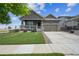 Charming single-Gathering home with a well-manicured lawn, front porch, and a two-car garage under a bright blue sky at 17788 Olive St, Broomfield, CO 80023