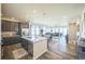 Open concept kitchen features dark cabinets, stainless steel appliances, granite countertops, and a large island at 17788 Olive St, Broomfield, CO 80023
