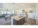 Open-concept kitchen with a large island, stainless steel appliances, and seamlessly flows into the dining and living areas at 17788 Olive St, Broomfield, CO 80023