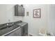 Laundry room with front loading washer and dryer and grey cabinets at 17788 Olive St, Broomfield, CO 80023