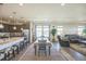 Open living space featuring a kitchen island, dining table, and a comfortable living area with ample natural light at 17788 Olive St, Broomfield, CO 80023