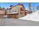 Exterior of the condo building with attached garages and snowy landscape at 303 Pelican Cir # 1901, Breckenridge, CO 80424