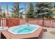 Outdoor hot tub on a patio with a wood fence and snowy trees beyond at 303 Pelican Cir # 1901, Breckenridge, CO 80424