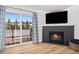 An open-concept living room with fireplace, balcony access, and a wall-mounted flat screen television at 303 Pelican Cir # 1901, Breckenridge, CO 80424