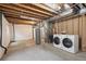 Unfinished basement with open ceiling, water heater, drywall and new washer dryer at 10685 Cherrybrook Cir, Highlands Ranch, CO 80126