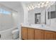 Bright bathroom with a double sink vanity, tiled bathtub and shower featuring a window at 10685 Cherrybrook Cir, Highlands Ranch, CO 80126