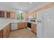 Kitchen with natural wood cabinets, white appliances, and tile floors with a bright window at 10685 Cherrybrook Cir, Highlands Ranch, CO 80126
