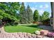Manicured backyard featuring a lush green lawn and brick accents at 12752 W Dakota Ave, Lakewood, CO 80228