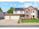 Charming brick and siding two-story home with a spacious three-car garage and solar panels on the roof at 12752 W Dakota Ave, Lakewood, CO 80228