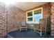 Covered patio with brick walls, window and rocking chairs; ideal for relaxing outdoors at 12752 W Dakota Ave, Lakewood, CO 80228