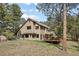 Home's backyard with deck and abundant trees at 4992 White House Trl, Evergreen, CO 80439