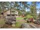 Picturesque backyard features mature trees, outdoor seating areas, and a wooden deck at 4992 White House Trl, Evergreen, CO 80439