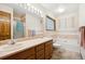 Bright bathroom with double sinks, large mirror, and separate tub and shower at 4992 White House Trl, Evergreen, CO 80439