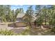 Charming two-story home with a stone facade and attached two-car garage surrounded by mature trees at 4992 White House Trl, Evergreen, CO 80439