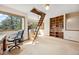 Bright office space featuring a ladder to the attic and custom-built shelving at 4992 White House Trl, Evergreen, CO 80439