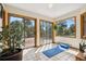 Bright sun room featuring tiled floor, multiple windows, and access to a wooden deck at 4992 White House Trl, Evergreen, CO 80439