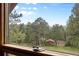 A scenic view of the wooded yard and outbuildings from a window in the home at 4992 White House Trl, Evergreen, CO 80439