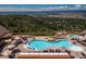 Aerial view of the community pool and lounge area with lush greenery and mountain views at 8014 Trinity Peak Ln, Castle Rock, CO 80108