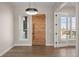 Bright foyer featuring a modern light fixture, sleek hardwood floors, and an impressive stained wood front door at 8014 Trinity Peak Ln, Castle Rock, CO 80108