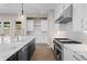 Modern kitchen featuring a large center island, chef's range, white cabinets, and stainless steel appliances at 8014 Trinity Peak Ln, Castle Rock, CO 80108