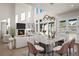 Open-concept living and dining room with a fireplace, tall ceilings, and plenty of natural light at 8014 Trinity Peak Ln, Castle Rock, CO 80108