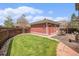 Spacious backyard with lush lawn, detached garage, and patio perfect for outdoor enjoyment at 3375 N Willow St, Denver, CO 80238