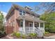 Beautiful two-story brick home with a white-railed front porch and manicured landscaping at 3375 N Willow St, Denver, CO 80238