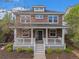 Stately brick home showcasing a charming front porch, lush landscaping, and inviting curb appeal at 3375 N Willow St, Denver, CO 80238