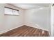 Bright bedroom featuring wood floors, a window with blinds, closet space, and neutral paint at 6140 Dudley St, Arvada, CO 80004