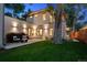 Beautiful backyard with a stone patio, lush greenery, and elegant outdoor lighting at 2377 S Humboldt St, Denver, CO 80210