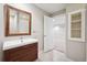 Bathroom featuring a vanity with wood-grain drawers and a framed mirror at 2377 S Humboldt St, Denver, CO 80210