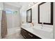 Bright bathroom with dual sinks, elegant mirrors, and shower-tub combination at 2377 S Humboldt St, Denver, CO 80210
