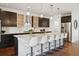 Bright, open kitchen with a large island, pendant lighting, stainless appliances, and dark cabinets at 2377 S Humboldt St, Denver, CO 80210