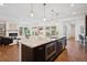 Large kitchen island with granite countertop and stainless steel appliances, with an open view of the living room at 2377 S Humboldt St, Denver, CO 80210